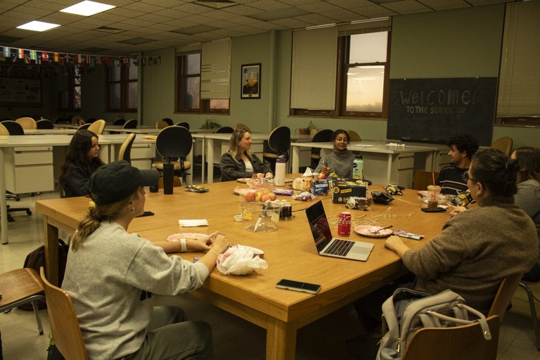 An image of people sitting around a large table having a meeting